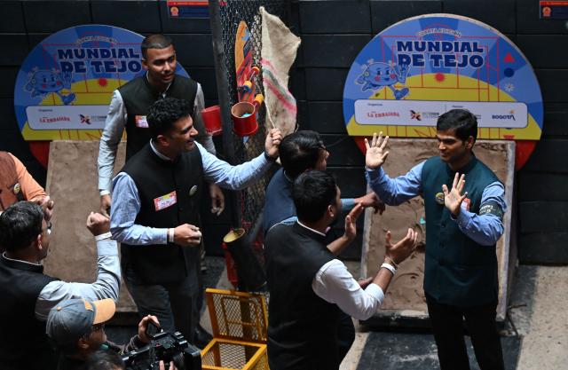 Members of the Indian delegation celebrate during the fourth edition of the Tejo World Championship, a traditional Colombian sport, in Bogota on October 2, 2026. Tejo is Colombia's national sport, in which players throw a heavy metal disc at a clay-filled target, aiming to hit small gunpowder-filled packets that explode on impact. (Photo by Raul ARBOLEDA / AFP)