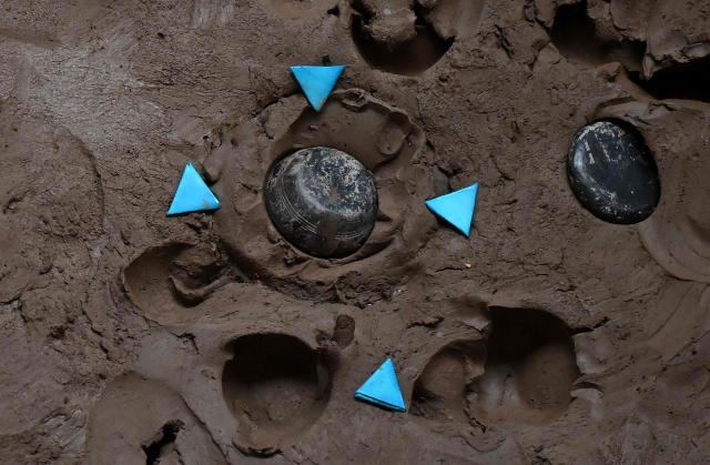Tejos are seen embedded in a clay target during the fourth edition of the Tejo World Championship, a traditional Colombian sport, in Bogota on October 2, 2026. Tejo is Colombia's national sport, in which players throw a heavy metal disc at a clay-filled target, aiming to hit small gunpowder-filled packets that explode on impact. (Photo by Raul ARBOLEDA / AFP)
