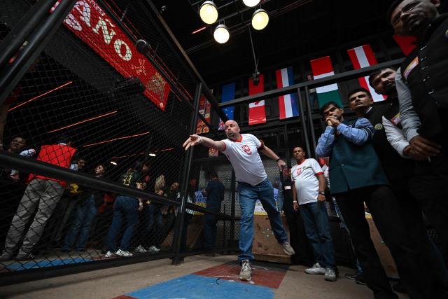 A member of the Polish delegation throws a tejo during the fourth edition of the Tejo World Championship, a traditional Colombian sport, in Bogota on October 2, 2026. Tejo is Colombia's national sport, in which players throw a heavy metal disc at a clay-filled target, aiming to hit small gunpowder-filled packets that explode on impact. (Photo by Raul ARBOLEDA / AFP)
