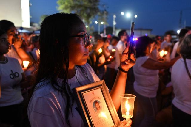 People hold candles during a vigil and prayer service called "Beam of Light," marking 100 days since the twin earthquakes that struck Venezuela on June 24, killing and displacing thousands of people, in Caraballeda, La Guaira state, Venezuela, on October 2, 2026. (Photo by Juan BARRETO / AFP)