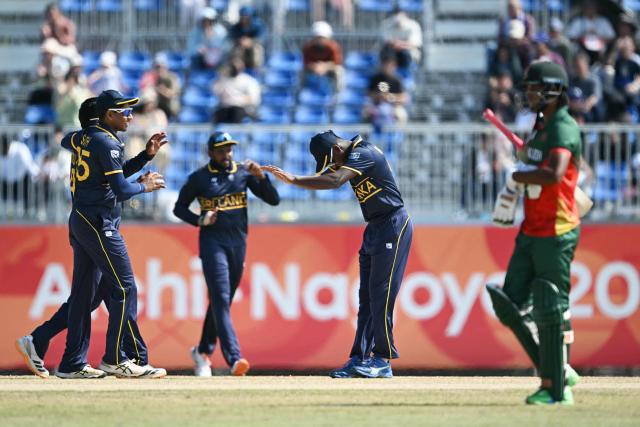Sri Lankan players (L) celebrate their win against Bangladesh in their cricket match for bronze during the 2026 Asian Games at the Korogi Athletic Park in Nisshin on October 3, 2026. (Photo by ANDREW CABALLERO-REYNOLDS / AFP)