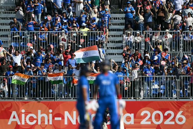 India fans celebrate their team reaching 100 runs during the men's cricket final match between Pakistan and India during the 2026 Asian Games at the Korogi Athletic Park in Nisshin on October 3, 2026. (Photo by ANDREW CABALLERO-REYNOLDS / AFP)