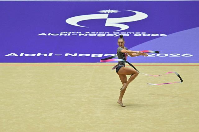 Kyrgyzstan's Zlata Olegovna Arkatova competes in the individual ribbon for the rhythmic gymnastics finals during the 2026 Asian Games at the Nagoya General Gymnasium in Nagoya on October 3, 2026. (Photo by MOHD RASFAN / AFP)