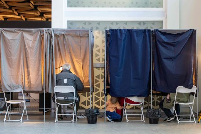 Voters are seen at a polling station in Riga during the general elections in Latvia on October 3, 2026. (Photo by Wojtek RADWANSKI / AFP)