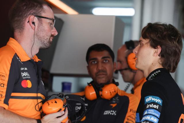 McLaren's Australian driver Oscar Piastri (R) talks to his team before the qualifying session of the Formula One Bahrain Grand Prix in Sepang on October 3, 2026. (Photo by Annice Lyn / POOL / AFP)