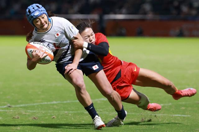 Japan's Yume Hirano (L) scores a try as China's Sun Yue tries to tackle her in the women's rugby sevens final match between Japan and China during the 2026 Asian Games at the Mizuho Park Rugby Field in Nagoya on October 3, 2026. (Photo by DAVID GRAY / AFP)