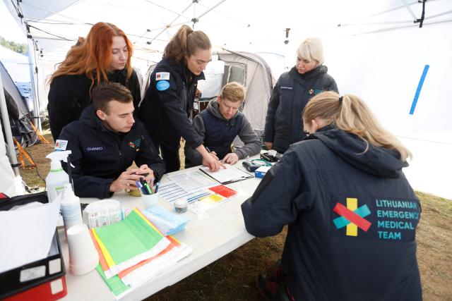 Exercise participants and volunteers take part in the "Vytis Skliautas 2026" civil protection exercise at a humanitarian training camp at the Lazdijai Hippodrome in Lazdijai, Lithuania on October 3, 2026, as the drill tests the country's readiness for mobilization. (Photo by Petras Malukas / AFP)