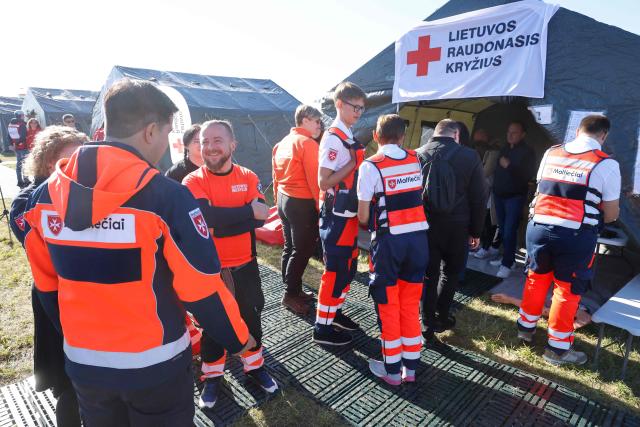 Exercise participants and volunteers take part in the "Vytis Skliautas 2026" civil protection exercise at a humanitarian training camp at the Lazdijai Hippodrome in Lazdijai, Lithuania on October 3, 2026, as the drill tests the country's readiness for mobilization. (Photo by Petras Malukas / AFP)
