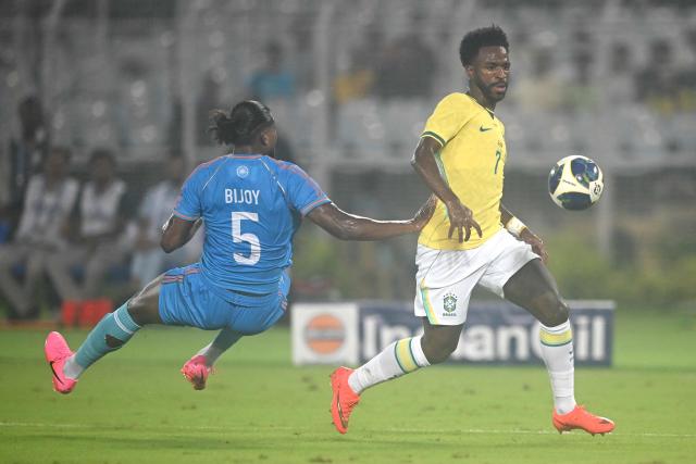 Brazil's forward #7 Vinicius Junior (R) and India's defender #5 Bijoy Varghese (L) fight for the ball during the international friendly football match between India and Brazil at the Salt Lake Stadium in Kolkata on October 3, 2026. (Photo by Dibyangshu SARKAR / AFP)