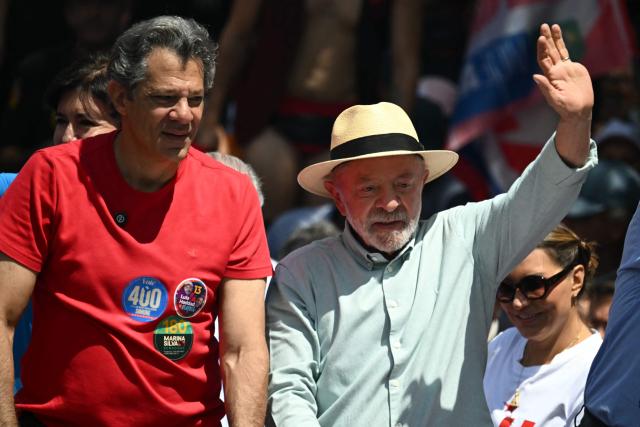 Brazil's President and presidential candidate Luiz Inacio Lula da Silva  waves next to his candidate for Sao Paulo's governor, Fernando Haddad during a campaign rally on the eve of the general election, in Sao Paulo, Brazil on October 3, 2026. Brazilians go to the polls on October 4, 2026, in a tight race led by leftist President Luiz Inacio Lula da Silva and right-wing senator Flavio Bolsonaro, son of imprisoned former president Jair Bolsonaro. (Photo by Luis ROBAYO / AFP)