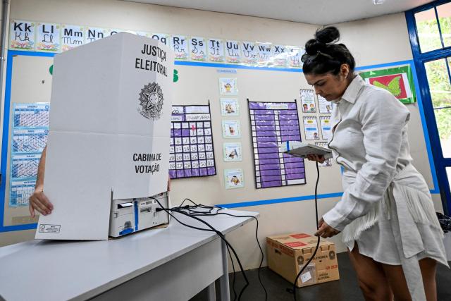 An employee of the Regional Electoral Court (TRE) sets up a voting booth at a polling station in a school in Brasilia, Brazil, on October 3, 2026, on the eve of the general election. Brazilians go to the polls on October 4, 2026, in a tight race led by leftist President Luiz Inacio Lula da Silva and right-wing senator Flavio Bolsonaro, son of former president Jair Bolsonaro, who is serving house arrest. (Photo by Evaristo Sa / AFP)