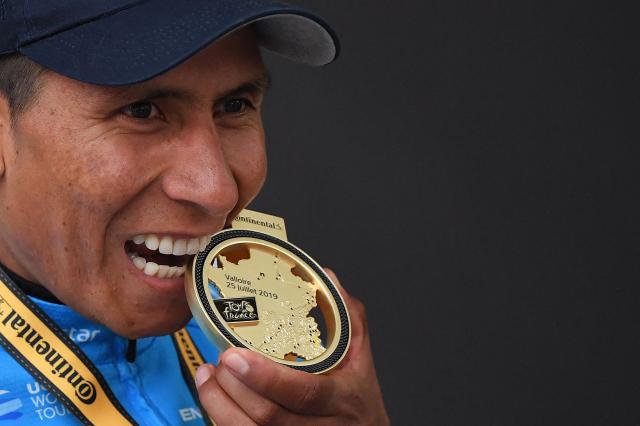(FILES) Stage winner Colombia's Nairo Quintana bites his medal as he celebrates his victory on the podium of the eighteenth stage of the 106th edition of the Tour de France cycling race between Embrun and Valloire, in Valloire, on July 25, 2019. Quintana, the son of a farming family in the Andes, turned into a daring beetle who shook Colombia to its core, fighting epic battles that made him a legend. (Photo by Marco Bertorello / AFP)