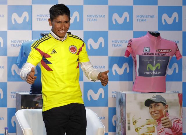(FILES) Colombian cyclist Nairo Quintana poses with the jersey of the Colombian national football team at the end of a press conference on his participation in the Tour de France in July, in Bogota on May 31, 2018. Quintana, the son of a farming family in the Andes, turned into a daring beetle who shook Colombia to its core, fighting epic battles that made him a legend. (Photo by John VIZCAINO / AFP)