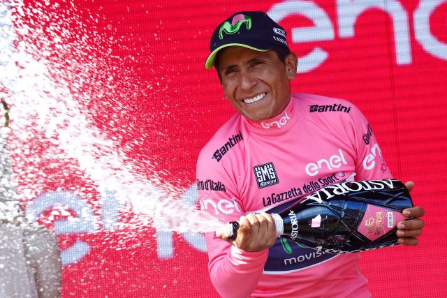 (FILES) Colombia's Nairo Quintana of Movistar team sprays champagne as he celebrates his overall leader pink jersey on the podium at the end of the 19th stage of 100th Giro d'Italia, Tour of Italy, from San Candido to Piancavallo of 191 km on May 26, 2017 in Piancavallo. Quintana, the son of a farming family in the Andes, turned into a daring beetle who shook Colombia to its core, fighting epic battles that made him a legend. (Photo by Luk BENIES / AFP)
