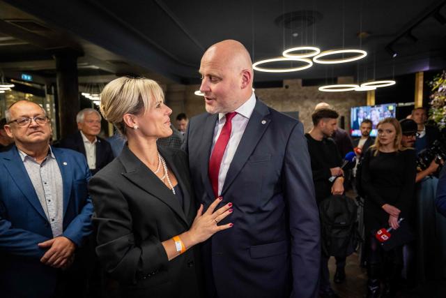Latvia's Prime Minister Andris Kulbergs and his wife Anna react after first exit poll results of the general election was announced during his Apvienotais Saraksts (United List) party’s election night in Riga on October 3, 2026. (Photo by Wojtek RADWANSKI / AFP)