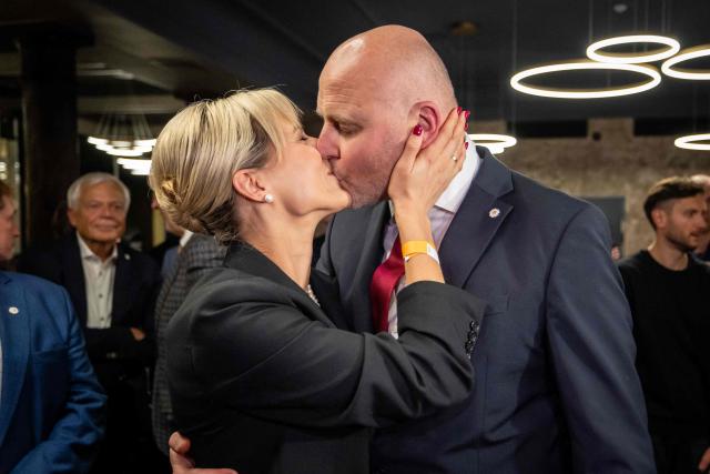 Latvia's Prime Minister Andris Kulbergs kisses his wife Anna after first exit poll results of the general election was announced during his Apvienotais Saraksts (United List) party’s election night in Riga on October 3, 2026. (Photo by Wojtek RADWANSKI / AFP)