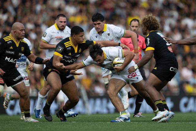 Clermont's Mathys Belaubre (C) is tackled during the French Top 14 rugby union match between Stade Rochelais and ASM Clermont Auvergne at the Marcel-Deflandre Stadium in La Rochelle on October 3, 2026. (Photo by XAVIER LEOTY / AFP)