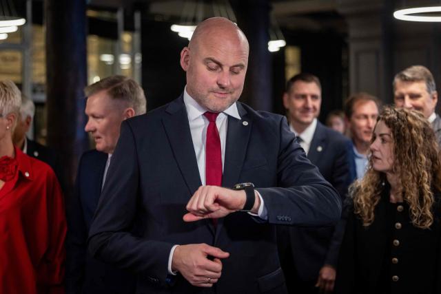 Latvia's Prime Minister Andris Kulbergs looks at his watch as he waits for the first exit poll results of the general election during his Apvienotais Saraksts (United List) party’s election night in Riga on October 3, 2026. (Photo by Wojtek RADWANSKI / AFP)