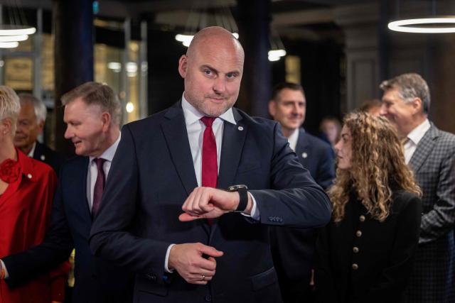 Latvia's Prime Minister Andris Kulbergs looks at his watch as he waits for the first exit poll results of the general election during his Apvienotais Saraksts (United List) party’s election night in Riga on October 3, 2026. (Photo by Wojtek RADWANSKI / AFP)