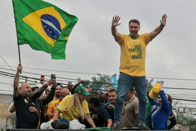 Brazil's right-wing senator and presidential candidate Flavio Bolsonaro of the Liberal Party (PL) waves during a campaign rally on the eve of the general election, in Campo Grande neighborhood, in the western zone of Rio de Janeiro, Brazil on October 3, 2026. Brazilians go to the polls on October 4, 2026, in a tight race led by leftist President Luiz Inacio Lula da Silva and right-wing senator Flavio Bolsonaro, son of former president Jair Bolsonaro, who is serving house arrest. (Photo by Douglas SHINEIDR / AFP)