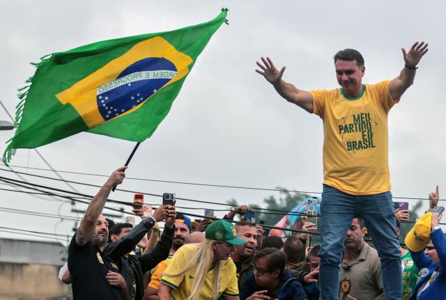 Brazil's right-wing senator and presidential candidate Flavio Bolsonaro of the Liberal Party (PL) waves during a campaign rally on the eve of the general election, in Campo Grande neighborhood, in the western zone of Rio de Janeiro, Brazil on October 3, 2026. Brazilians go to the polls on October 4, 2026, in a tight race led by leftist President Luiz Inacio Lula da Silva and right-wing senator Flavio Bolsonaro, son of former president Jair Bolsonaro, who is serving house arrest. (Photo by Douglas SHINEIDR / AFP)