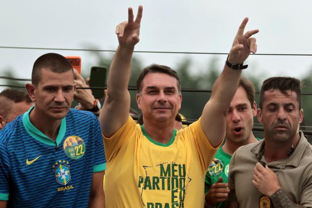 Brazil's right-wing senator and presidential candidate Flavio Bolsonaro of the Liberal Party (PL) gestures next to federal deputy and candidate for governor of Rio de Janeiro, Douglas Ruas (L) during a campaign rally on the eve of the general election, in Campo Grande neighborhood, in the western zone of Rio de Janeiro, Brazil on October 3, 2026. Brazilians go to the polls on October 4, 2026, in a tight race led by leftist President Luiz Inacio Lula da Silva and right-wing senator Flavio Bolsonaro, son of former president Jair Bolsonaro, who is serving house arrest. (Photo by Douglas SHINEIDR / AFP)