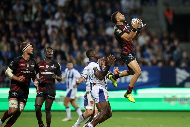 Toulouse's French wing Matthis Lebel (R) grabs the ball during the French Top14 rugby union match between Castres Olympique and Stade Toulousain at Stade Pierre Fabre in Castres, southwestern France, on October 3, 2026. (Photo by Valentine CHAPUIS / AFP)
