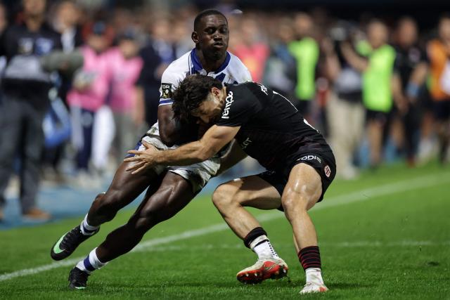 Castres' Cameroonian wing Christian Ambadiang (L) is tackled during the French Top14 rugby union match between Castres Olympique and Stade Toulousain at Stade Pierre Fabre in Castres, southwestern France, on October 3, 2026. (Photo by Valentine CHAPUIS / AFP)