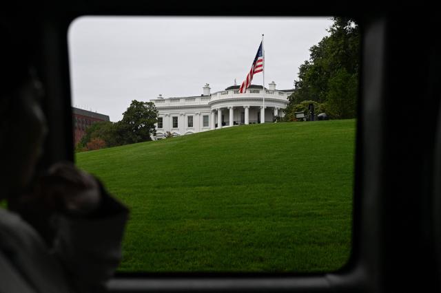 The White House as seen through the window of a motorcade as US President Donald Trump leaves the White House, in Washington, DC, on October 3, 2026. President Trump will travelling to Ohio for a midterm campaign rally later today. (Photo by Alex WROBLEWSKI / AFP)