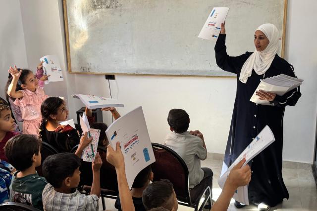 Palestinian teacher Hadeel Zourob, a mathematics teacher and school administrator who fled the Gaza Strip in April 2024 and currently resides in El-Arish, North Sinai, teaches a class of displaced children from Gaza, at a Palestinian school in the Egyptian city of El-Arish, near the border with the Gaza Strip, on October 1, 2026. On Egypt’s Sinai Peninsula, Hadeel Zourob welcomes dozens of pupils from Gaza to the only Palestinian school in the region – a school she set up for these children displaced by the war. “They fled to Egypt and found themselves here with no school and no access to education,” explains the teacher, who is in her thirties and was herself displaced by the war in Gaza. “So I decided to set up a school for them.” (Photo by Amr AHMED / AFP)