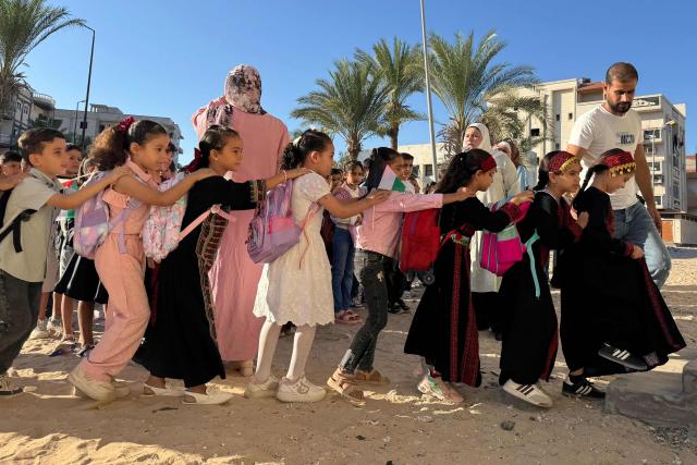 Displaced children from the Gaza Strip, stand in line as they attend a Palestinian school in the Egyptian city of El-Arish, near the border with the Gaza Strip, on October 1, 2026. On Egypt’s Sinai Peninsula, Palestinian teacher Hadeel Zourob welcomes dozens of pupils from Gaza to the only Palestinian school in the region – a school she set up for these children displaced by the war. Hadeel Zourob arrived in April 2024, six months after the war began. Together with other teachers, she began teaching a small group of children in a rented building. (Photo by Amr AHMED / AFP)