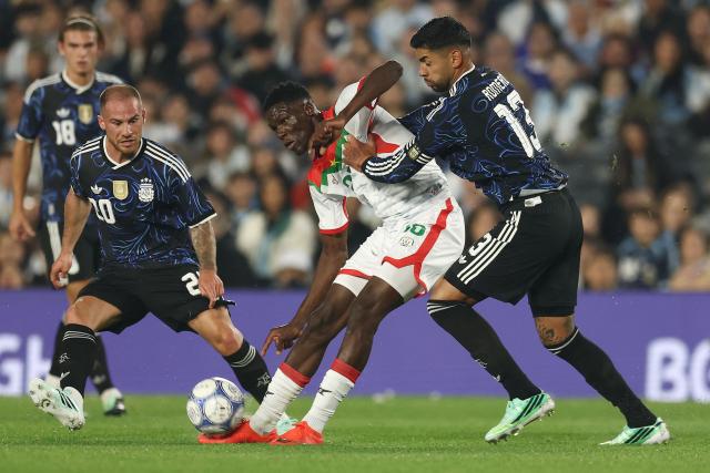 Burkina Faso's defender #25 Naser Ouattara (C) fights for the ball with Argentina's midfielder #20 Alexis Mac Allister (L) and defender #13 Cristian Romero (R) during the international friendly football match between Argentina and Burkina Faso at the Mas Monumental stadium in Buenos Aires on October 3, 2026. (Photo by Alejandro PAGNI / AFP)