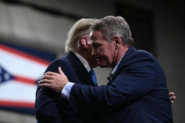 US President Donald Trump hugs US Senator Jon Husten (R-OH) after speaking during a campaign rally in Vandalia, Ohio, on October 3, 2026. (Photo by Brendan SMIALOWSKI / AFP)