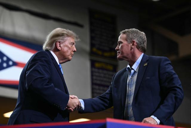 US President Donald Trump shakes hands with US Senator Jon Husten (R-OH) after speaking during a campaign rally in Vandalia, Ohio, on October 3, 2026. (Photo by Brendan SMIALOWSKI / AFP)