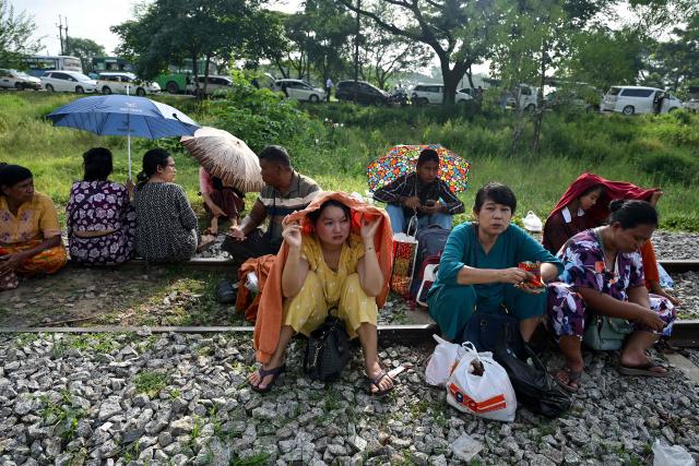 Family members wait outside the Myanmar Navy base in Thanlyin on October 4, 2026 to welcome their loved ones returning from Malaysia. Nearly 1,500 Myanmar migrants from Malaysia arrived in their war-torn home country on October 4, a Myanmar official said, returned under an opaque repatriation scheme that rights monitors say cannot assure their safety. (Photo by Sai Aung MAIN / AFP)