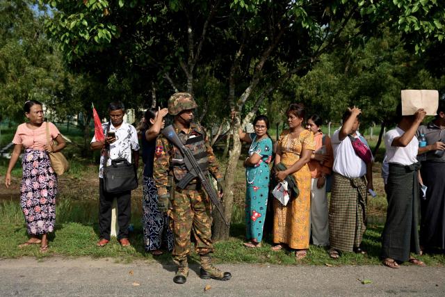 Family members wait outside the Myanmar Navy base in Thanlyin on October 4, 2026 to welcome their loved ones returning from Malaysia. Nearly 1,500 Myanmar migrants from Malaysia arrived in their war-torn home country on October 4, a Myanmar official said, returned under an opaque repatriation scheme that rights monitors say cannot assure their safety. (Photo by Sai Aung MAIN / AFP)