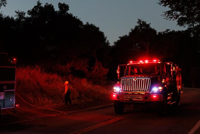 A US Department of Agriculture Forest Service fire engine drives through Bouquet Canyon as the Bouquet Fire burns in the Angeles National Forest near Santa Clarita, California on October 3, 2026. The fire, which has prompted evacuation orders in the area, come as an extended heat wave hits Southern California. (Photo by Blake Fagan / AFP)