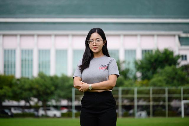 In this photo taken on October 1, 2026, Thai student activist Nutthanit Duangmusit poses on a football field during an interview with AFP on the campus of Thammasat University in Bangkok. Fifty years after a student demonstration against dictatorship ended in a massacre, Thailand's latest generation of protesters still face the threat of prosecution, jail or exile. (Photo by ANTHONY WALLACE / AFP) / To go with 'THAILAND-POLITICS-PROTEST-HISTORY,FOCUS' by Chayanit ITTHIPONGMAETEE and Thanaporn PROMYAMYAI