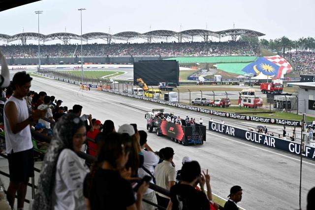 Supporters cheer as drivers ride on a truck during the Dirver's Parade ahead of the Formula One Bahrain Grand Prix in Sepang on October 4, 2026. (Photo by Lillian SUWANRUMPHA / AFP)
