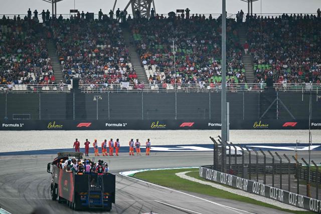 Supporters watch as drivers ride on a truck during the Dirver's Parade ahead of the Formula One Bahrain Grand Prix in Sepang on October 4, 2026. (Photo by Lillian SUWANRUMPHA / AFP)