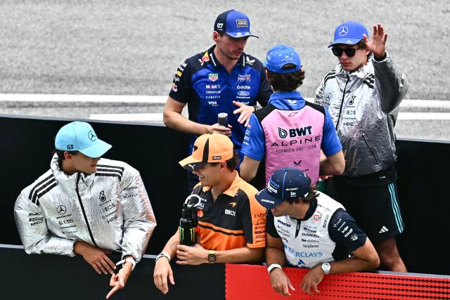 Mercedes' British driver George Russell (front L) speaks with McLaren's British driver Lando Norris (front C) and Williams' Spanish driver Carlos Sainz (front R) as Red Bull Racing's Dutch driver Max Verstappen (back L) speaks to Alpine's Argentine driver Franco Colapinto (back C) and Mercedes' Italian driver Kimi Antonelli (back R) during the Dirver's Parade ahead of the Formula One Bahrain Grand Prix in Sepang on October 4, 2026. (Photo by Lillian SUWANRUMPHA / AFP)
