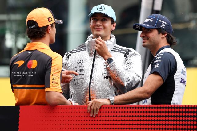 McLaren's British driver Lando Norris (L) speaks with Mercedes' British driver George Russell (C) and Williams' Spanish driver Carlos Sainz (R) during the Dirver's Parade ahead of the Formula One Bahrain Grand Prix in Sepang on October 4, 2026. (Photo by I-HWA CHENG / AFP)