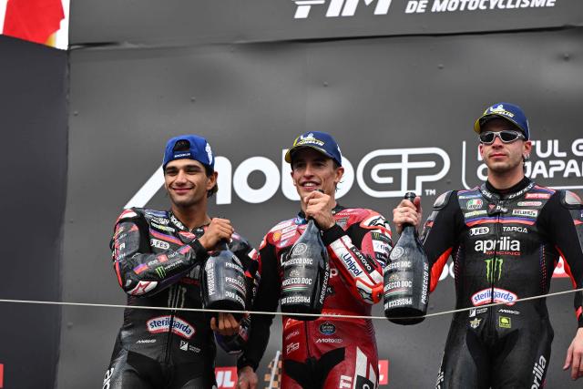Japanese GP winner Ducati Lenovo Team rider Marc Marquez of Spain (C) poses with second place Aprilia Racing rider Jorge Martin of Spain (L) and third place Aprilia Racing rider Marco Bezzecchi of Italy (R) on the podium during the MotoGP Japanese Grand Prix at the Mobility Resort Motegi in Motegi, Tochigi prefecture on October 4, 2026. (Photo by Toshifumi KITAMURA / AFP)