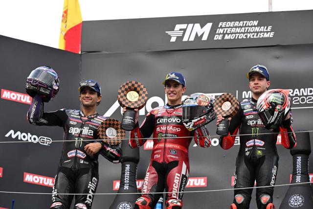 Japanese GP winner Ducati Lenovo Team rider Marc Marquez of Spain (C) poses with second place Aprilia Racing rider Jorge Martin of Spain (L) and third place Aprilia Racing rider Marco Bezzecchi of Italy (R) on the podium during the MotoGP Japanese Grand Prix at the Mobility Resort Motegi in Motegi, Tochigi prefecture on October 4, 2026. (Photo by Toshifumi KITAMURA / AFP)