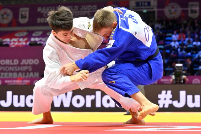 Ukraine's Artem Lesiuk (blue) competes against Mongolia's Sukhbat Byambasuren in the men's under 60 kg qualification round at the World Judo Championships in Baku on October 4, 2026. (Photo by Alexander NEMENOV / AFP)