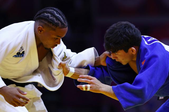 Kazakhstan's Aman Bakytzhan (blue) competes against Cuba's Jonathan Charon in the men's under 60 kg qualification round at the World Judo Championships in Baku on October 4, 2026. (Photo by Anne-Christine POUJOULAT / AFP)