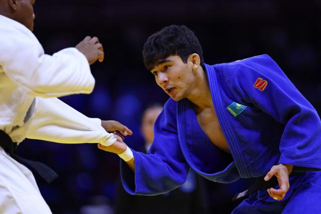 Kazakhstan's Aman Bakytzhan (blue) competes against Cuba's Jonathan Charon in the men's under 60 kg qualification round at the World Judo Championships in Baku on October 4, 2026. (Photo by Anne-Christine POUJOULAT / AFP)