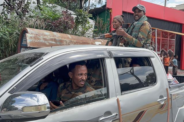 Members of the Ethiopian pro-government Tigray Peace Force (TPF) gesture as residents welcome them while they ride in a pickup truck during a street patrol after Ethiopian federal and allied forces entered the Tigray capital of Mekelle, on October 4, 2026. Ethiopian federal troops on October 3, 2026 entered the Tigray state capital Mekelle, which was largely abandoned by the region's rebel authorities, a humanitarian source told AFP."Ethiopian federal forces and allied forces have reportedly been observed in Mekelle city... across various locations," the source said, citing reports from staff on the ground. (Photo by AFP)