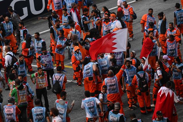 Marshals from Bahrain react after the race of the Formula One Bahrain Grand Prix in Sepang on October 4, 2026. (Photo by Jade GAO / AFP)