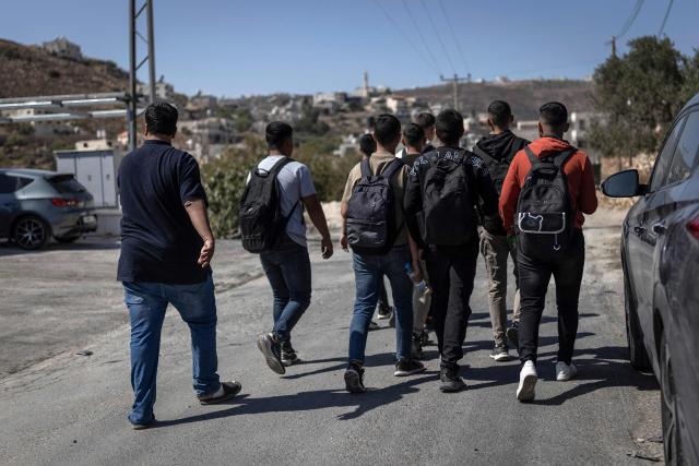 School students walk along the road between al-Mughayyir and Abu Falah villages near Ramallah in the Israeli-occupied West Bank, on October 4, 2026. (Photo by Ilia YEFIMOVICH / AFP)